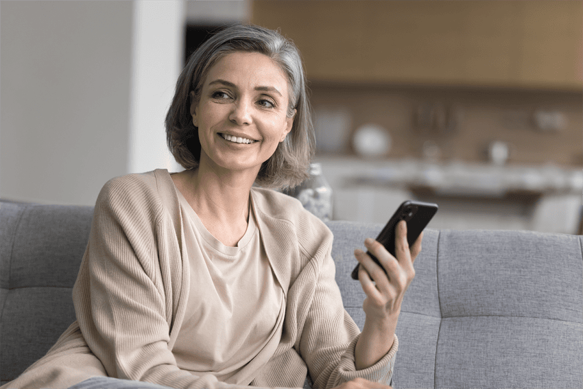Mature woman sitting on the sofa smiling in good health